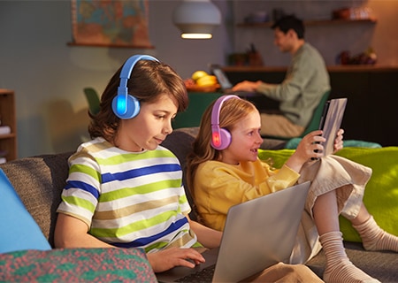 Παιδιά που χρησιμοποιούν ακουστικά κεφαλής της Philips για παιδιά με λειτουργία φωτιζόμενων τμημάτων σε διάφορα χρώματα