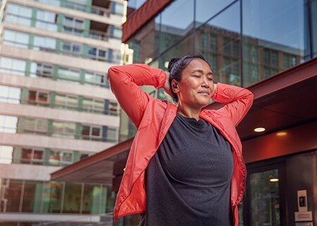 Γυναίκα που χρησιμοποιεί ασύρματα ακουστικά Philips A5508 σε εξωτερικούς χώρους
