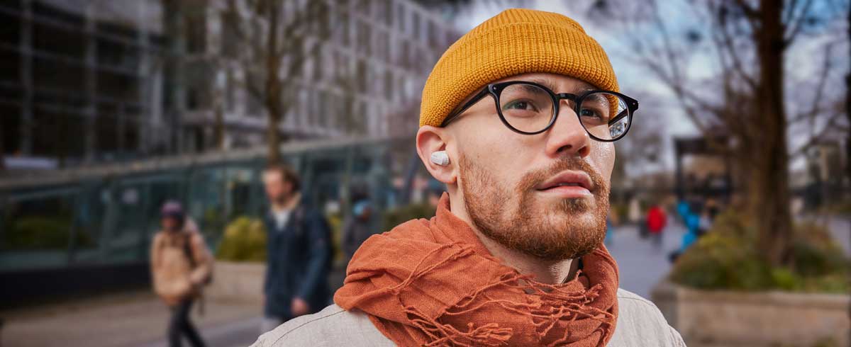 Κοντινή φωτογραφία ενός άνδρα που φορά αληθινά ασύρματα ακουστικά